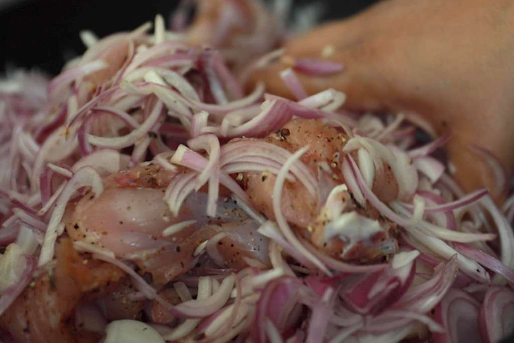 mixing onions and chicken for marination