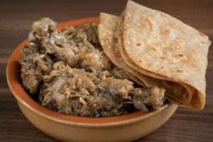 chappathi and chicken curry on traditional plate