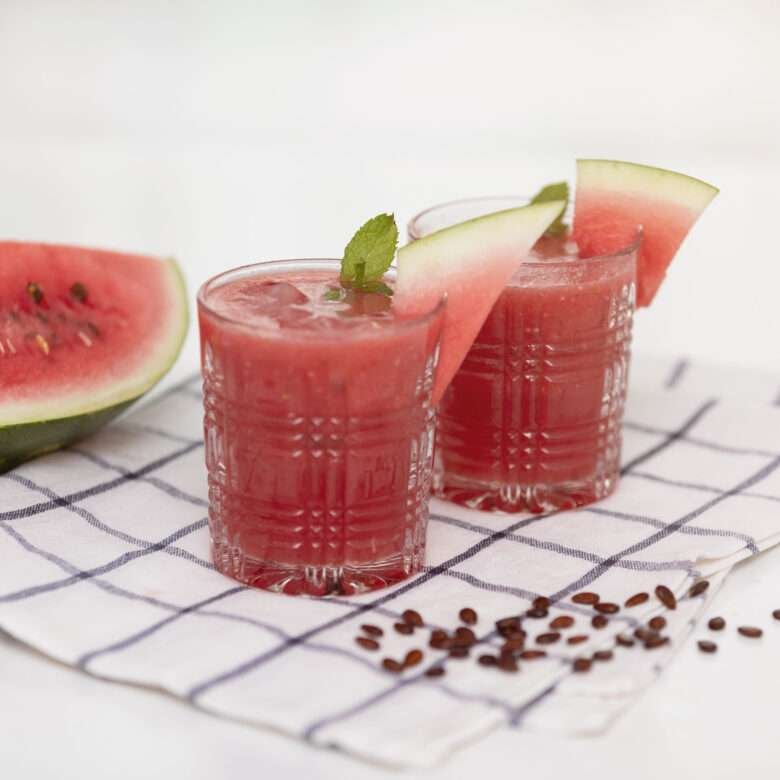 two glass of watermelon cooler and some watermelon seeds