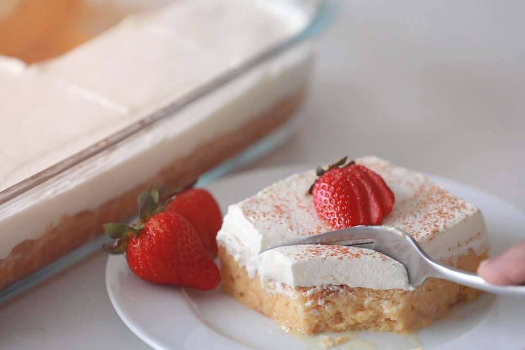 mexican tres leches cake on plate with strawberry topping