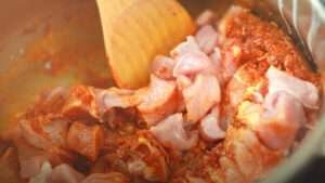 mixing spicy masala with beef cubes